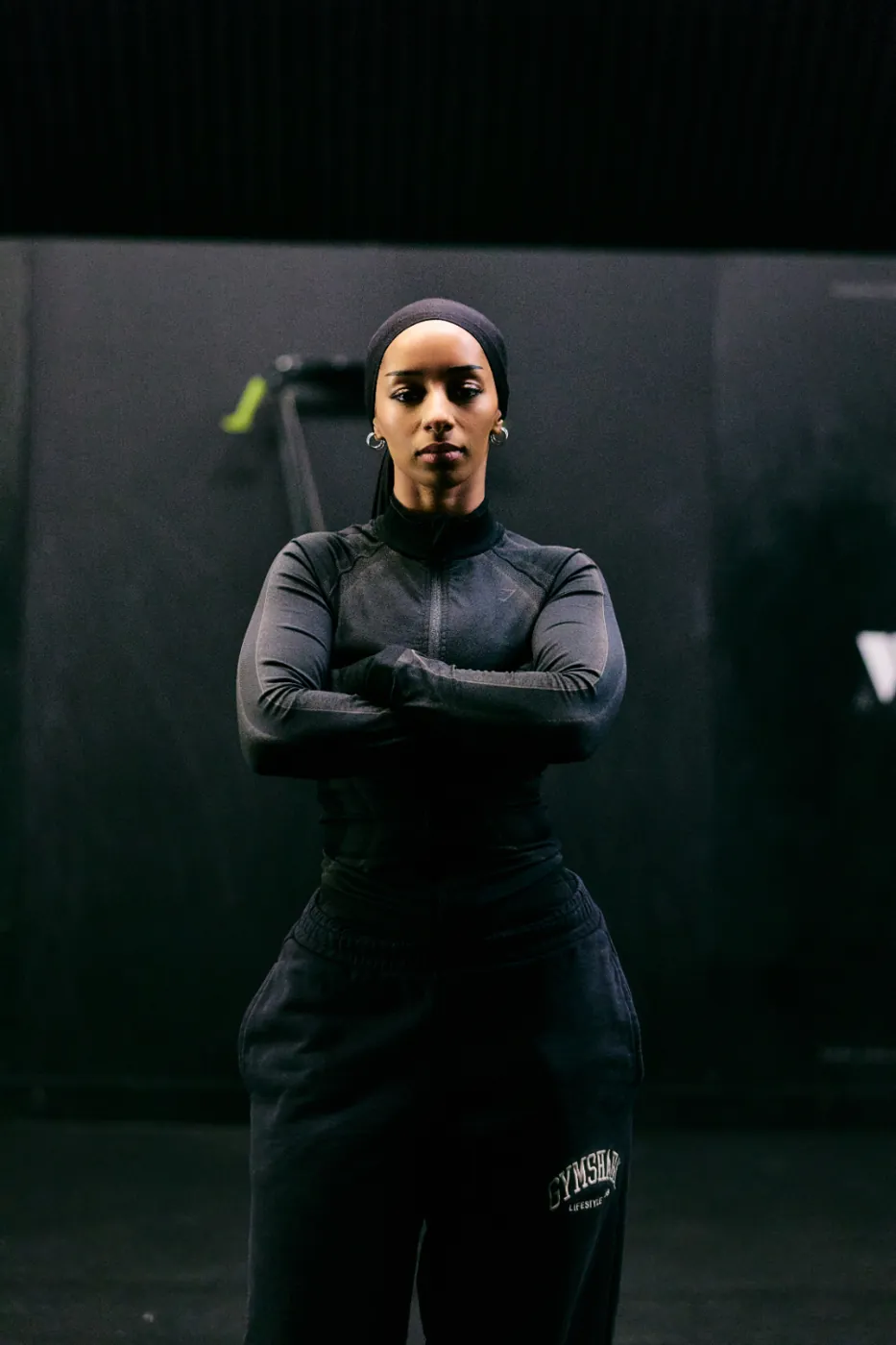 Aliya, founder of Mind to Motion, arms crossed in the training studio