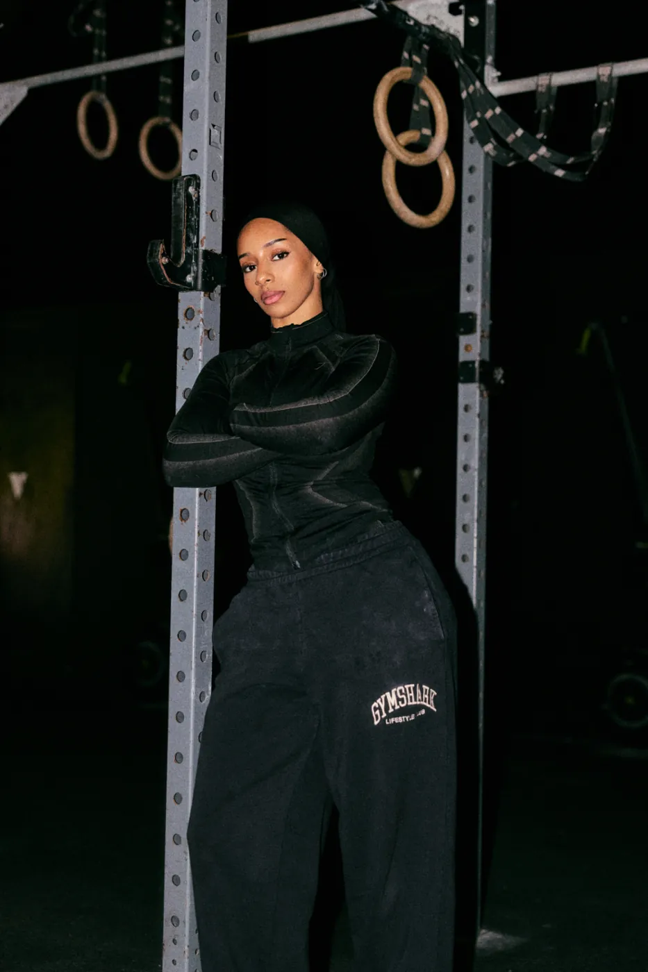 Aliya standing at the rig under a set of gymnastic rings